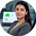 Portrait of Niharika Kopystynska seated at a desk with a laptop in a modern legal office