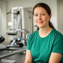 Physiotherapist seated beside rehabilitation equipment in a modern practice